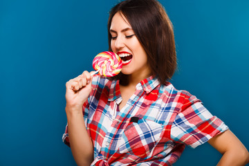 Obraz premium Nice brunette woman is going to eat big colored candy