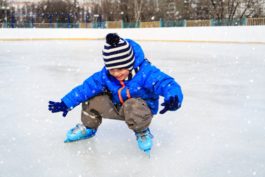 cute little boy learning to skate in winter