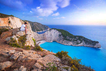 Fototapeta premium Man watching sunset over Navagio beach on Zakynthos island, Greece