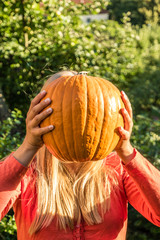 Großer Riesenkürbis mit blonder Frau