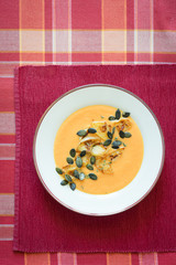 Pumpkin soup served with caramelized apples, pumpkin seeds and thyme