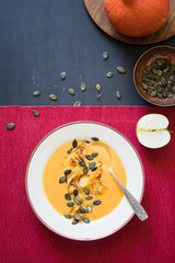 Pumpkin soup with caramelized apples, pumpkin seeds and thyme leaves
