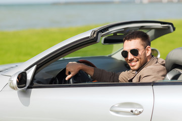 happy man driving cabriolet car outdoors