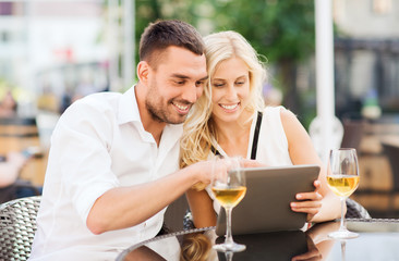 happy couple with tablet pc at restaurant lounge