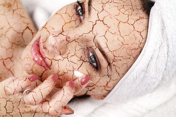 Woman applying moisturizing cream on her face