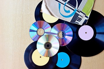 Vinyl record discs ans CD on wooden background. Top view