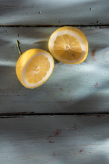a yellow lemon cut in half on a wooden background
