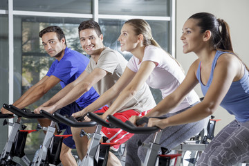 group of 4 cycling at gym