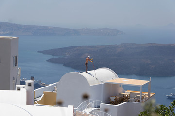 871 - man painting the roofs of the houses of Santorini