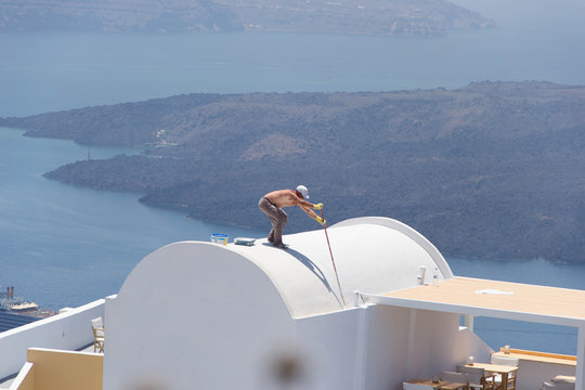 873 - man painting the roofs of the houses of Santorini