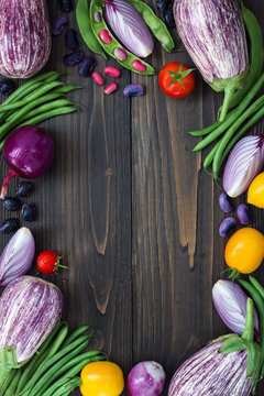 Mix of fresh farmers market vegetable from above on the old wooden board with copy space. Healthy eating background. Top view