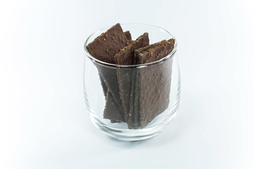 thin sheet dark chocolate in a glass on white background