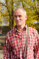 Naklejka na ściany i meble Portrait of a serious man in a plaid shirt on the background of