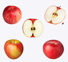 Three whole apples and two halved apples isolated on white