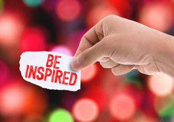 Piece of paper with the word Be Inspired with bokeh background