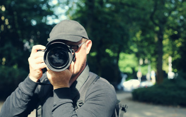 Young man with professional camera outdoors