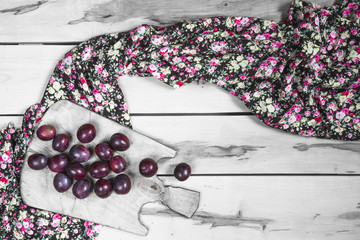 Ripe plums on the wooden background