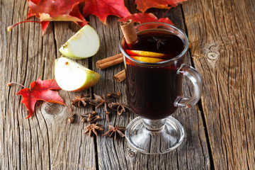 Mulled wine and spices on weathered wooden table
