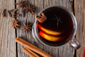 Mulled wine and spices on weathered wooden table