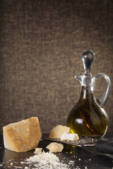 grated cheese, grated parmesan cheese with a grater and a jar and bottle of olive  oil