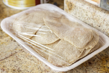 Package of breaded meat fillets before cooking