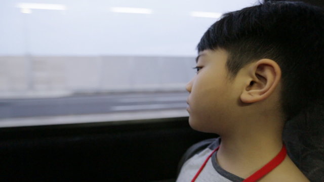 Young Asian Boy Riding Bus And Looking Out The Window