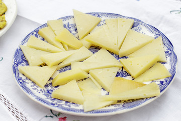 Dish of Manchego cheese pieces cut in triangles