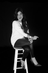 Georgeous tan woman posing on a bar stool black and white