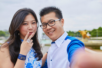 Beautiful Asian couple taking selfie in Paris
