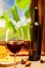 Red wine bottle and glass on wooden table
