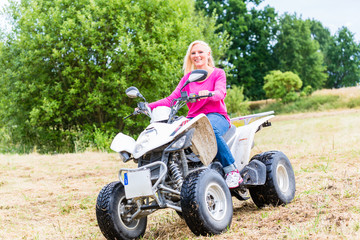 Fototapeta na wymiar Woman driving off-road with quad bike or ATV