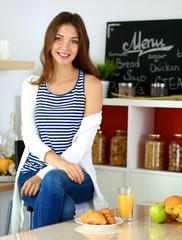 Portrait of a pretty woman sitting in the kitchen 