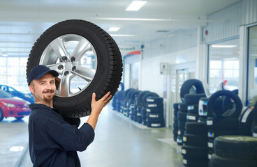 Car mechanic with a tire .