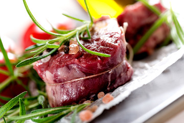 Raw beef steak with peppercorns and herbs
