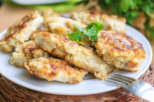 Roasted chicken cutlets on white plate.