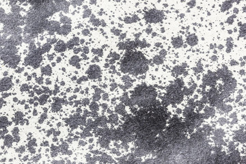 Black stains on gray paper texture.