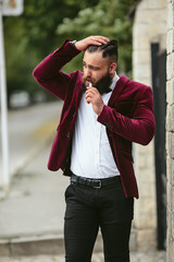 rich man with a beard smokes electronic cigarette