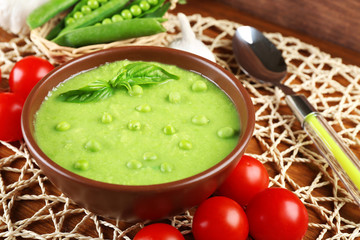 Tasty peas soup and vegetables on table close up