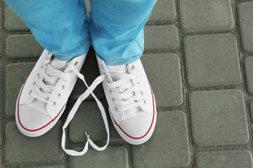 Female feet in gum shoes on asphalt background