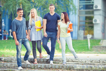 Four young students walking in university campus