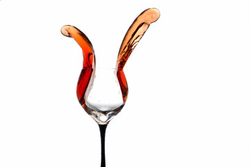 stream of wine being poured into a glass isolated on a white background
