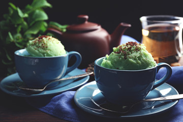 Homemade Green tea ice-cream in cup, on wooden background