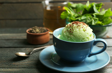 Homemade Green tea ice-cream in cup, on wooden background