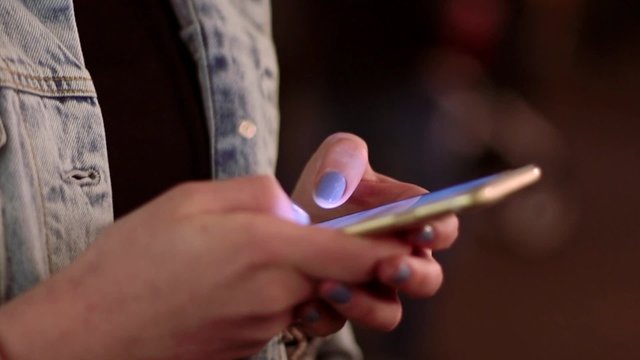 Junge Frau tippt auf Smartphone