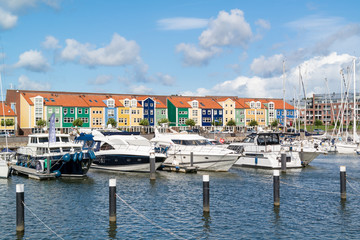 Colourful facades of houses and motor yachts in marina Hellevoetsluis, Netherlands