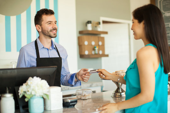 Woman paying at a cash register with a credit card