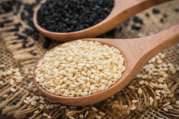 White sesame and black sesame seed on wooden spoon