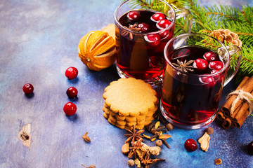 Hot xmas punch with spices and cranberry in glass cups. Christmas or new year greeting card. Selective focus