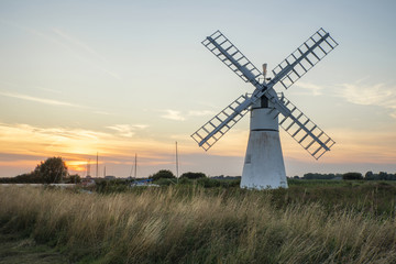 Fototapeta na wymiar Stunning landscape of windmill and river at dawn on Summer morni