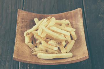 french fries on wood background - soft focus with vintage film f